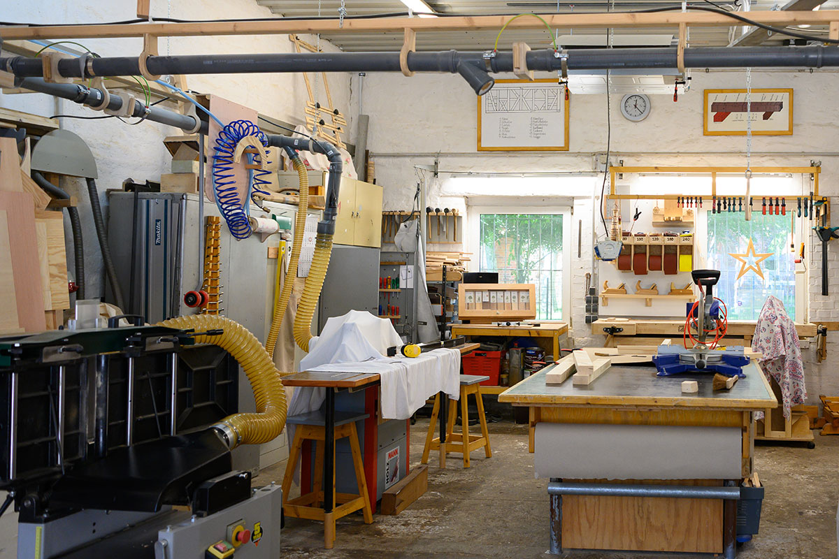 Gut ausgestattete Holzwerkstatt mit Werkbänken, Maschinen und Absauganlage als Einsatzort für den Bundesfreiwilligendienst.